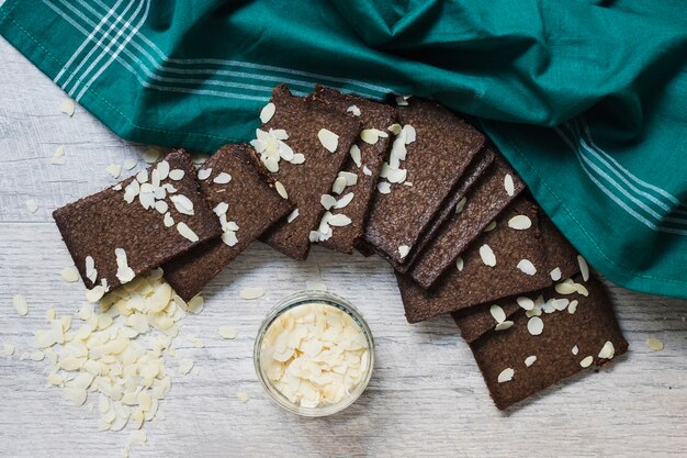 Una vista aerea di fette di mandorle e fette di cioccolato fondente su fondo di legno