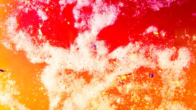 Una vista aerea di rosso e giallo una bomba da bagno schiuma in acqua