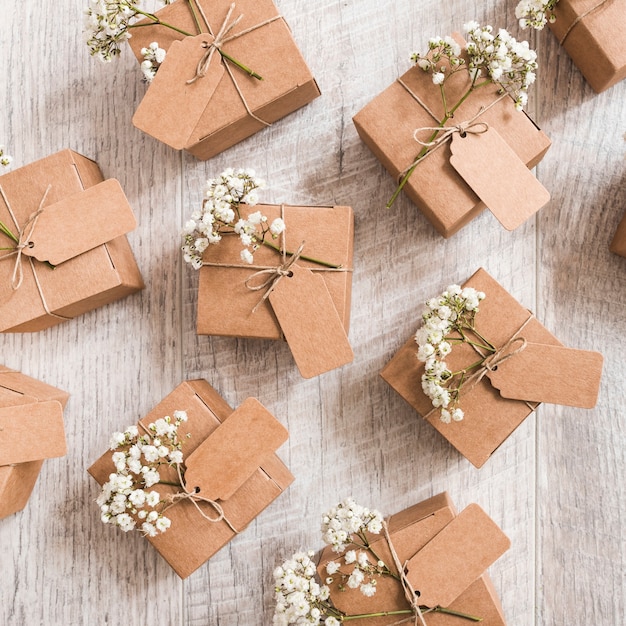 Una vista aerea di scatole regalo di nozze con fiori baby&#39;s-breath sulla scrivania in legno