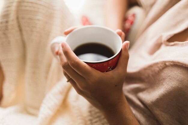 Una vista aerea di una ragazza che tiene la tazza di caffè in mano