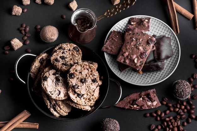 Una vista ambientale dei biscotti e del cioccolato di muesli del cioccolato su priorità bassa nera