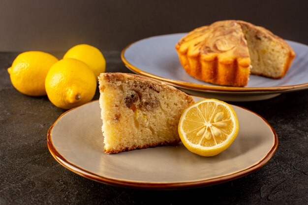 Una vista chiusa frontale pezzo di torta dolce delizioso delizioso choco fetta di torta all'interno del piatto beige insieme a limoni gialli