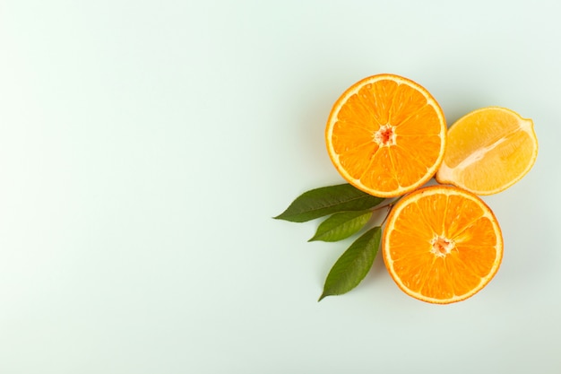 Una vista dall'alto affettato arancione fresco maturo succoso morbido isolato mezzo taglio pezzi con foglie verdi su sfondo bianco agrumi di colore di frutta