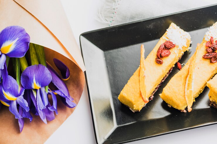 Foto gratuito una vista dall'alto del bouquet di fiori di iris con deliziose fette di torta
