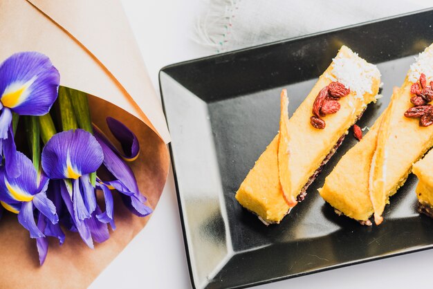 Una vista dall&#39;alto del bouquet di fiori di iris con deliziose fette di torta