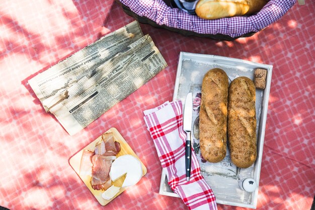 Una vista dall&#39;alto del vassoio con pane; Bacon; formaggio sul panno rosso