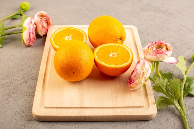 Una vista dall'alto di arance fresche acide mature affettate e agrume intero succosa succosa vitamina tropicale giallo sulla scrivania crema