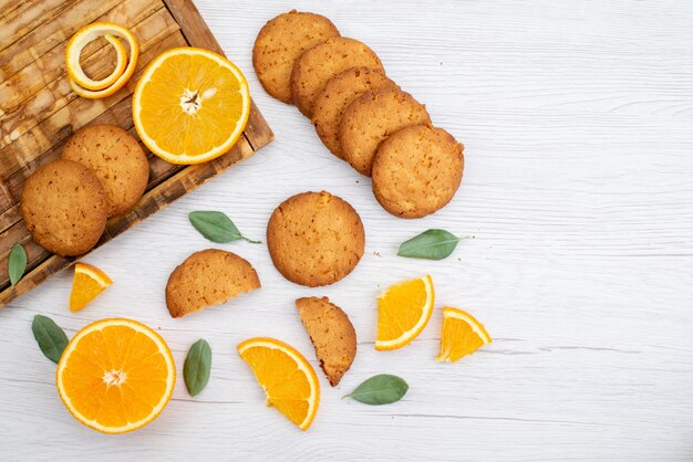 Una vista dall'alto di biscotti aromatizzati all'arancia con fette d'arancia fresche sul biscotto di frutta leggera scrivania