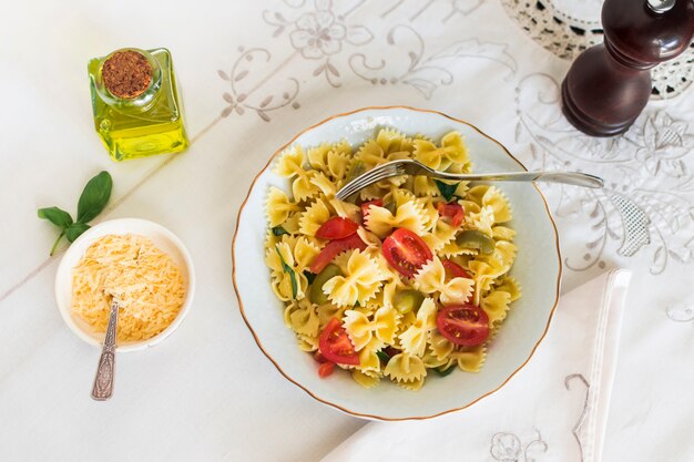 Una vista dall&#39;alto di farfalle con formaggio e olive sulla tovaglia