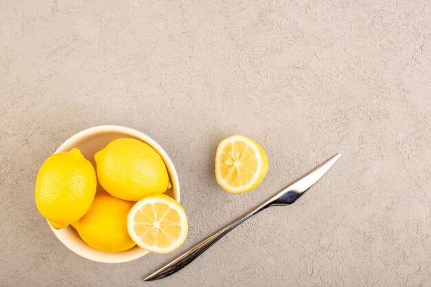 Una vista dall'alto limoni freschi acerbi maturi interi agrumi tropicali tropicali giallo vitamina sulla scrivania crema