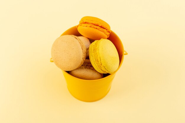 Una vista dall'alto macarons francesi colorati all'interno del canestro giallo