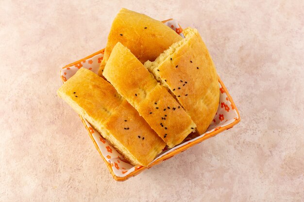 Una vista dall'alto pane cotto caldo gustoso affettato fresco all'interno del cestino del pane sul rosa