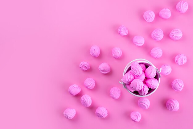 Una vista dall'alto rosa, caramelle deliziose e dolci tutte sul colore rosa, zucchero candito dolce