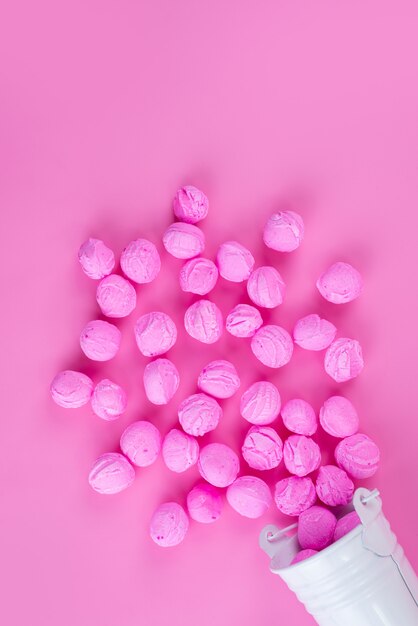 Una vista dall'alto rosa, caramelle deliziose sul colore rosa, zucchero candito dolce