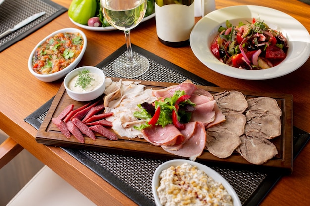 Una vista dall'alto salsicce sulla scrivania con vino bianco e verdure sulla carne del ristorante pasto cibo tavola