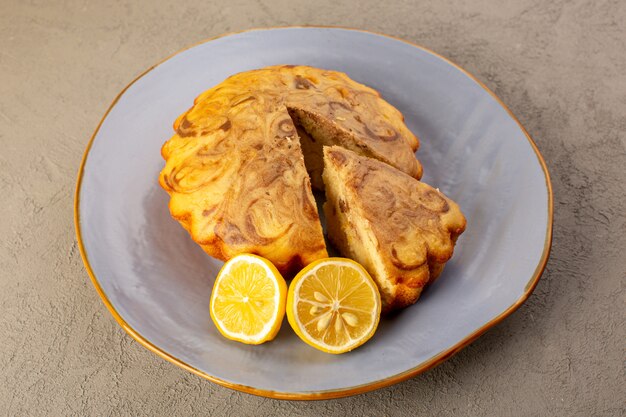 Una vista dall'alto torta dolce delizioso delizioso choco torta affettata all'interno del piatto blu insieme a fettine di limone sullo sfondo grigio