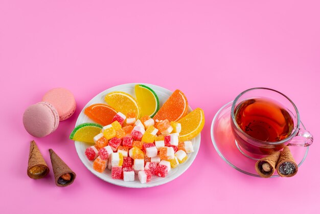 Una vista frontale caramelle colorate e marmellate per l'ora del tè su zucchero dolce rosa, confettura di tè