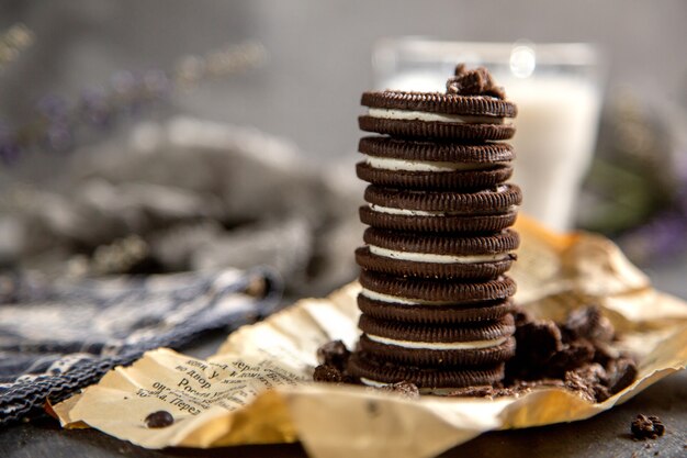 Una vista frontale choco biscotti dolci e deliziosi con un bicchiere di latte sullo scrittorio grigio biscotto biscotto cioccolato zucchero dolce