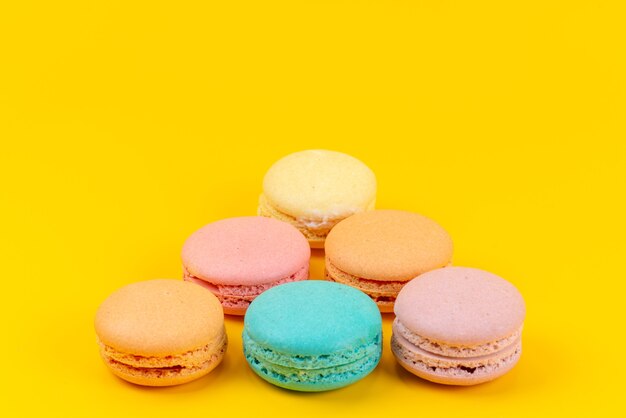 Una vista frontale colorati macarons francesi deliziosi sul giallo, colore biscotto torta