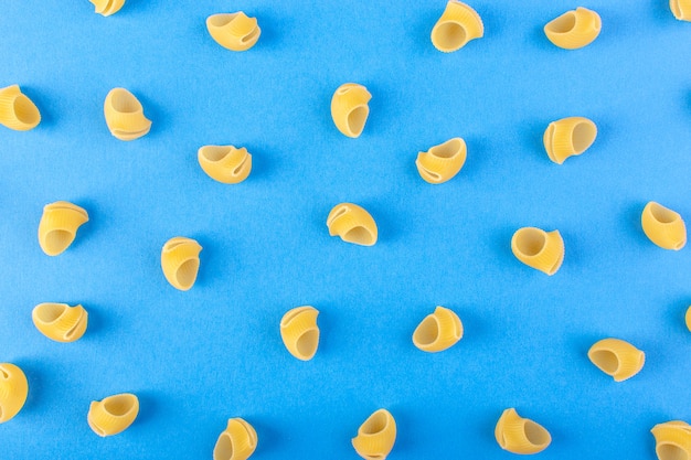 Una vista frontale ha isolato la pasta gialla poco cruda sulla pasta blu degli spaghetti del pasto dell'alimento del fondo