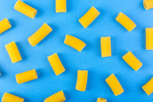 Una vista frontale ha isolato la pasta gialla poco cruda sulla pasta blu degli spaghetti del pasto dell'alimento del fondo