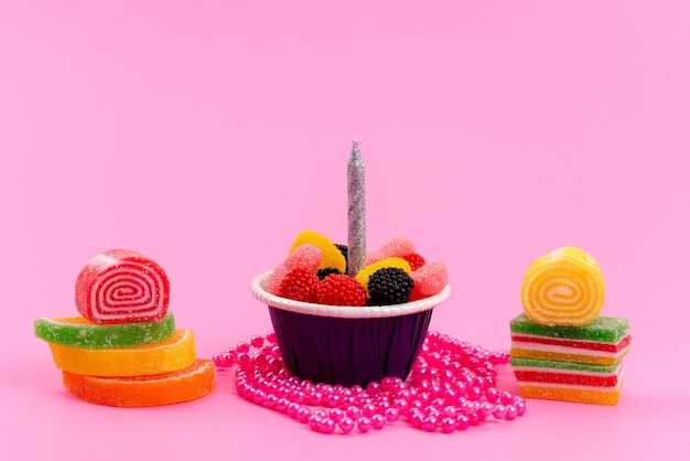 Una vista frontale marmellate e caramelle colorato dolce isolato su pasticceria di zucchero rosa e dolce