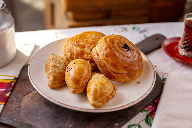 Una vista frontale pasticcini al forno qogals e altri biscotti da forno tea time gustosa pasta pasta pasticceria sul tavolo