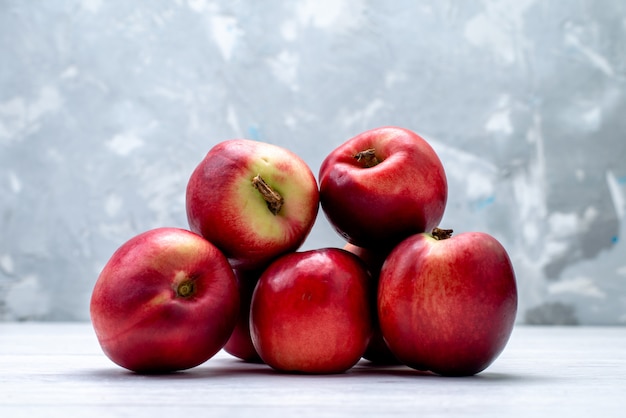 Una vista frontale pesche fresche aspre e pastose sullo sfondo bianco frutta colore estate fresca