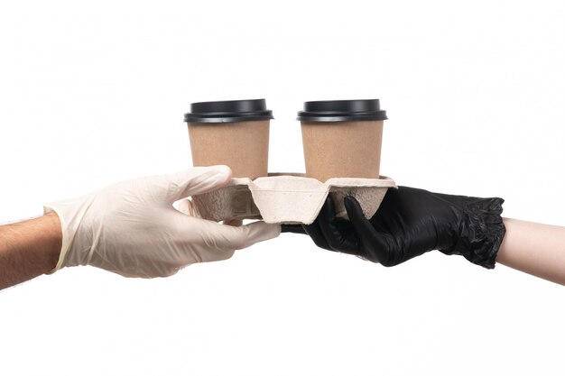 Una vista frontale tazze di caffè che viene consegnato da femmina a maschio