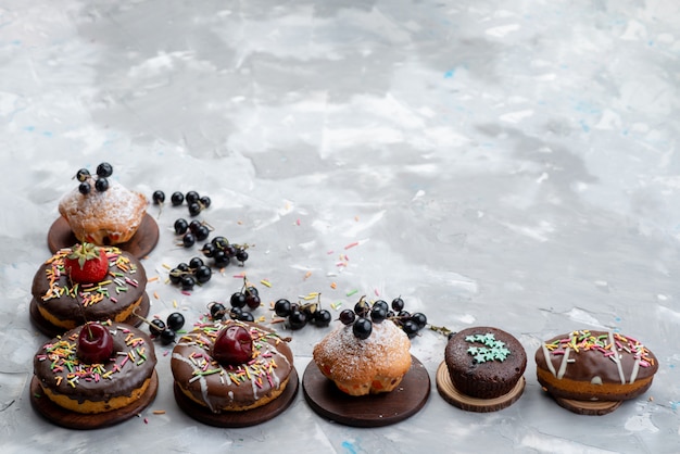 Una vista frontale torte e ciambelle a base di cioccolato con frutta e caramelle torta biscotto