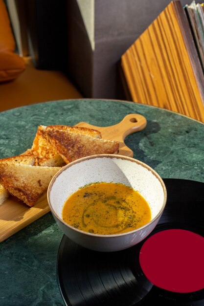Una zuppa di vista superiore all'interno del piatto con pane sulla minestra della foto del pasto del cibo della tavola