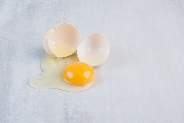 Unico uovo rotto aperto sul tavolo di marmo.