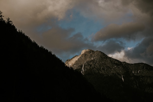 Uno splendido scenario di una gamma di alte montagne rocciose sotto un cielo nuvoloso