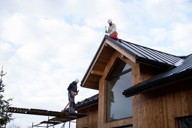 Uomini a tiro lungo che lavorano sul tetto