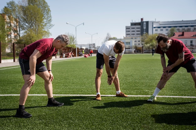 Uomini a tutto campo che si allungano prima della partita