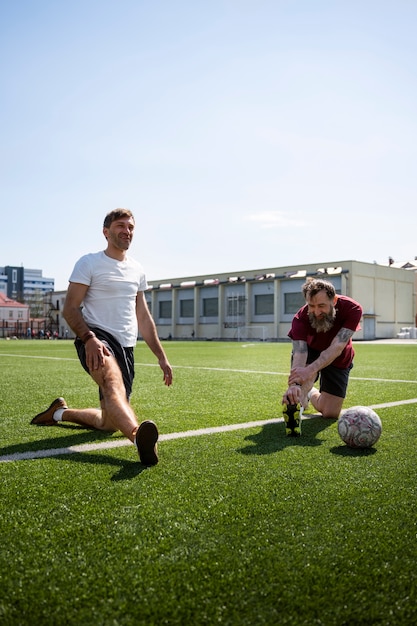 Uomini a tutto campo che si allungano prima della partita