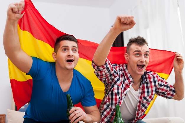 Uomini che guardano la partita di calcio in TV e tifano per la squadra spagnola