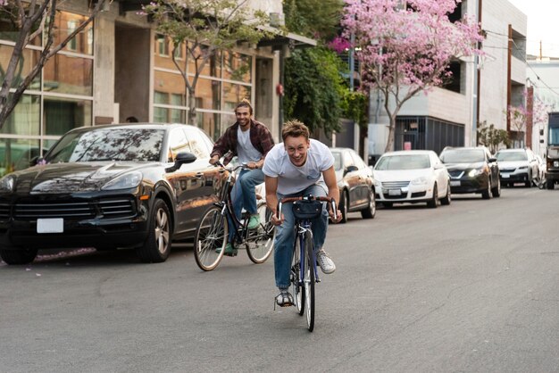 Uomini che guidano le biciclette nel colpo pieno della città