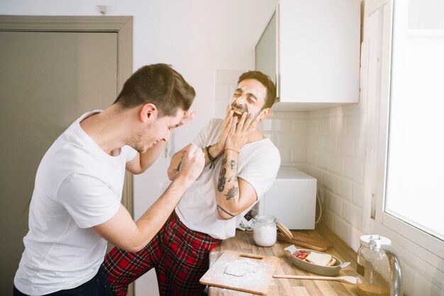 Uomini che ridono godendo la mattina in cucina