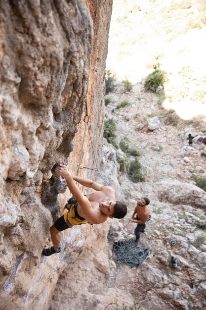 Uomini che si arrampicano su una montagna con equipaggiamento di sicurezza