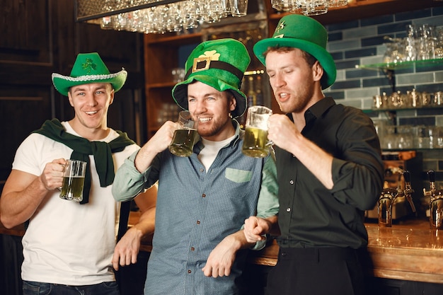 Uomini con cappelli verdi. Gli amici celebrano il giorno di San Patrizio. Celebrazione in un pub.