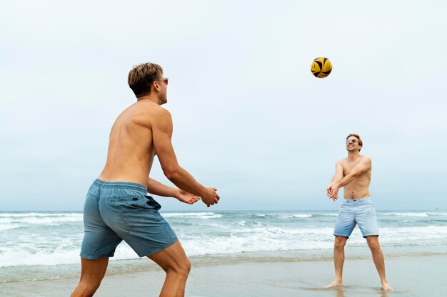 Uomini di tiro medio che giocano a pallavolo