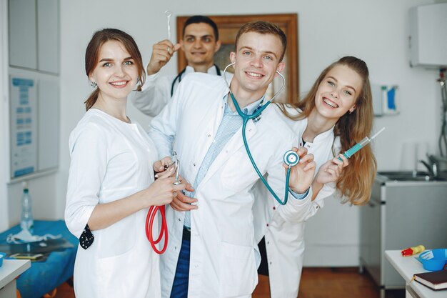 Uomini e donne in camici da ospedale tengono in mano attrezzature mediche