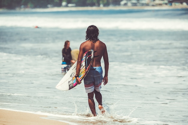 uomini e ragazze stanno surfando