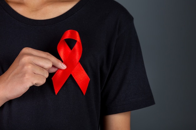 Uomini in possesso di nastri rossi. Consapevolezza concettuale. HIV. Giornata mondiale contro l'AIDS e Giornata mondiale della salute sessuale.