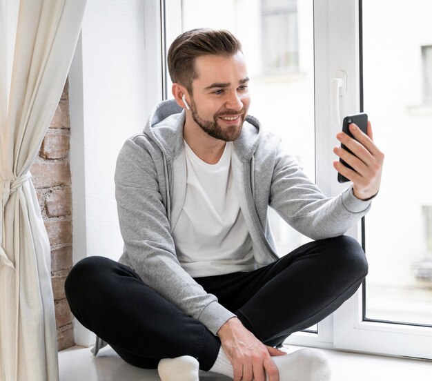 Uomo a casa con videochiamata con la famiglia