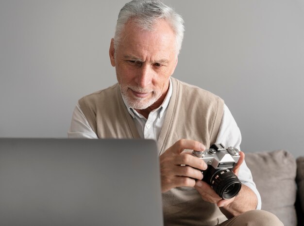 Uomo a colpo medio che tiene in mano una macchina fotografica