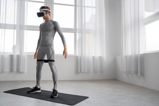 Uomo a figura intera che fa fitness con gli occhiali vr