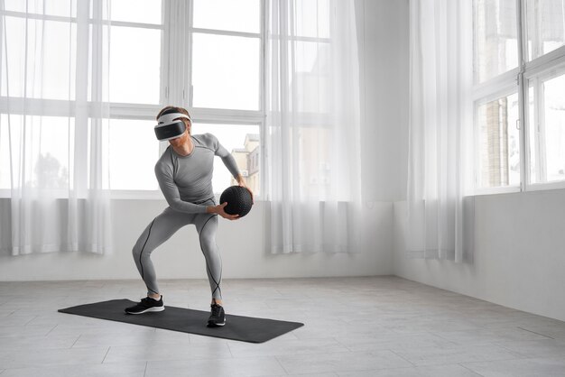 Uomo a figura intera che fa fitness con gli occhiali vr