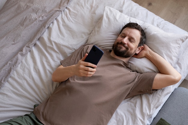 Uomo a letto con smartphone